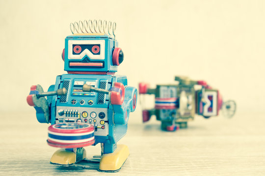 Old robot toy on wood table, vintage color style, vintage tone background.
