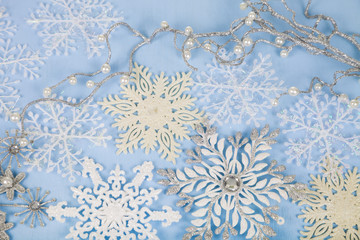 Silver decorative snowflakes on a blue wooden background. Christ