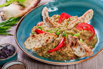 Salad baked eggplant with green onions, croutons and tomatoes on wooden background.  Ingredients on table