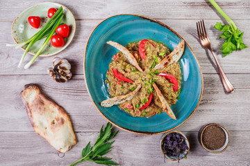 Salad baked eggplant with green onions, croutons and tomatoes on wooden background.  Ingredients on table