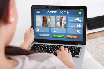 Woman Using Smart Home System On Laptop