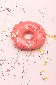 Pink glazed donut on pink background
