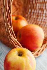 Apples in basket on a wooden table. 