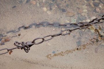 old rusty chain in water closeup