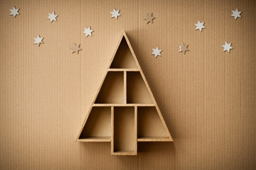 Christmas tree shaped gift box and decorations, on cardboard background