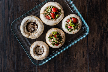 Mushrooms stuffed with vegetables before cooking.