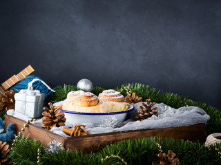 Cinnamon roll buns in enamel bowl on dark background
