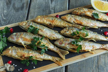 fried fish goatfish surmullet with lemon on board