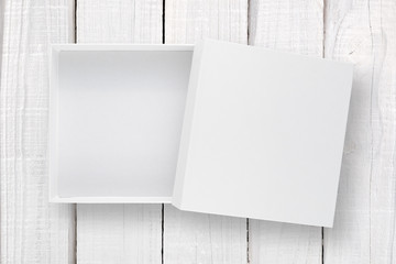 White box with cover on white wooden background