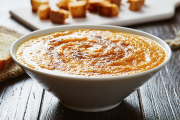 Pumpkin soup in white bowl