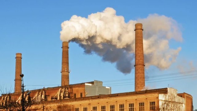 Factory plant smoke stack over blue sky background. Energy generation and air environment pollution industrial scene.