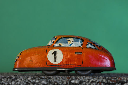 Orange vintage toy car on green background