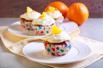 Orange cupcakes with frosting, served