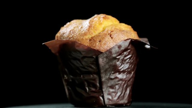 freshly baked muffin on a black background. video rotation