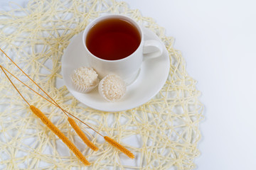 Simple still life in light tones. Cup with tea on a saucer and t