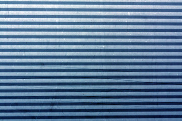 Corrugated blue metal plate surface.