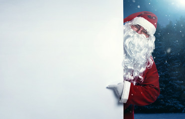 Santa Claus pointing on blank advertisement banner