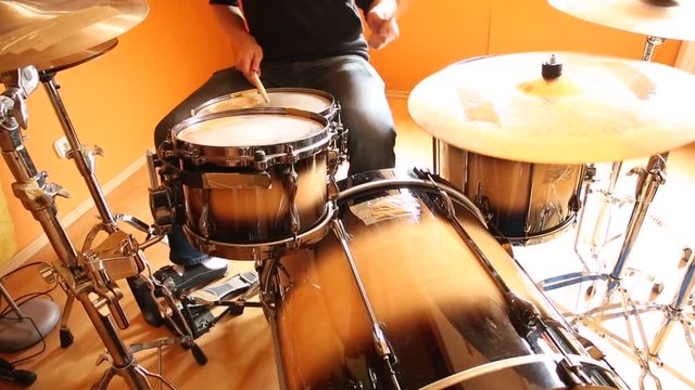 A drummer performing on his Drumset.
