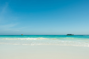 Fototapeta na wymiar Beautiful gentle wave at the tropical beach with blue sky