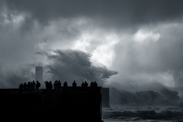 People silhouette looking at a sea storm