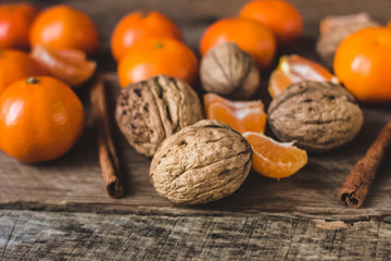 Christmas spirit: nuts, tangerines on a dark wooden background