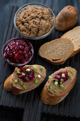 Sliced baguette with liver pate, cranberry sauce and onion