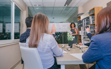 Obraz premium Widok pracy zespołowej z palcami w górę, aby zadawać pytania trenerce po spotkaniu biznesowym w siedzibie głównej