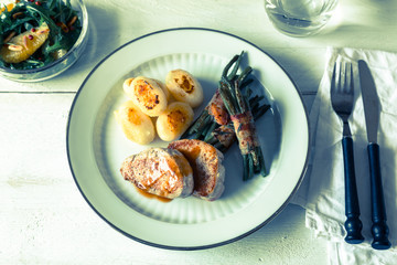 Schweinemedaillons mit Kartoffeln und Bohnen im Speckmantel