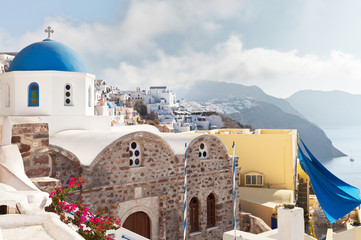 Greece. Santorini Island. Oia village. The Orthodox Church with traditional blue domes and white walls misty October morning