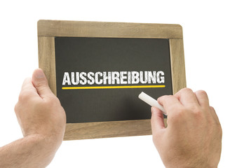 Auschreibung / Hand schreibt auf Kreidetafel