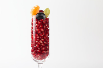 pomegranate seeds in the glass on a light background