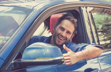 Man driver happy smiling showing thumbs up driving sport car
