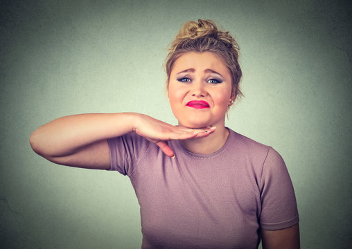 angry young woman gesturing with hand to stop talking