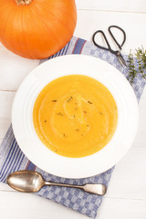 healthy pumpkin soup with thyme in a deep plate