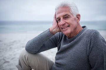 Fototapeta na wymiar Happy senior man sitting on the beach
