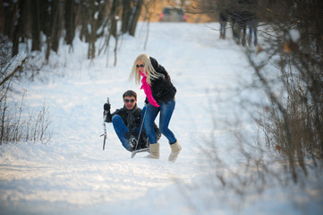 Fototapeta na wymiar young man and woman on a sled