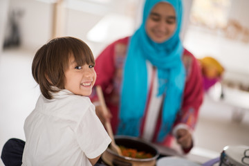 Muslim Arabic young mother and little cute son making food and h