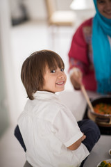Muslim Arabic young mother and little cute son making food and h