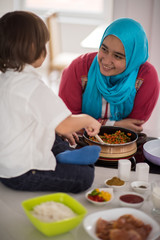 Muslim Arabic young mother and little cute son making food and h