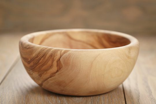 empty olive wood bowl on wooden table, shallow focus