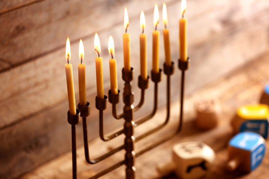 Menorah with candles for Hanukkah on blurred wooden background, close up