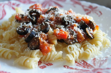 fusilli with tomato sauce, paprika and olives, sprinkled with Parmesan cheese