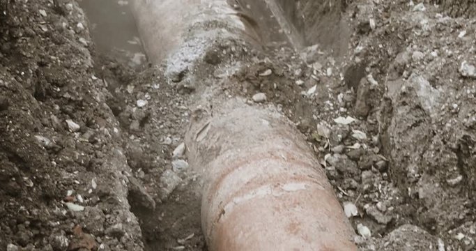 Old abndoned pipeline. Rusty pipe in trench half full of water