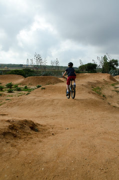 Child riding a bmx bike on a dirt track