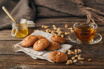 Homemade oatmeal cookies with a cup of tea on old wooden backgro