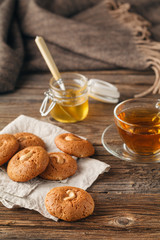 Cup of tea with oatmeal cookie on dark wooden table covert table