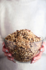 Glass bowl with granola in the woman hands