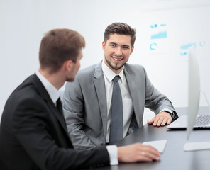 Image of two young businessmen discussing project at meeting