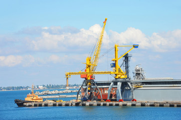 Fototapeta na wymiar Tugboat and port cargo crane
