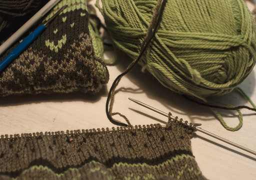 Knitted norway sweater with knitting needles and wool yarn. Freelance, hobby, home concept